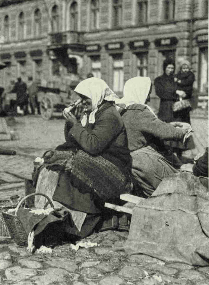 An Egg-seller Inspecting Her Wares in A Riga MarketThe virtue of every egg is proved by "candling" it with the aid of a square of brown paper wound to form a tube.Photograph by Maynard Owen Williams