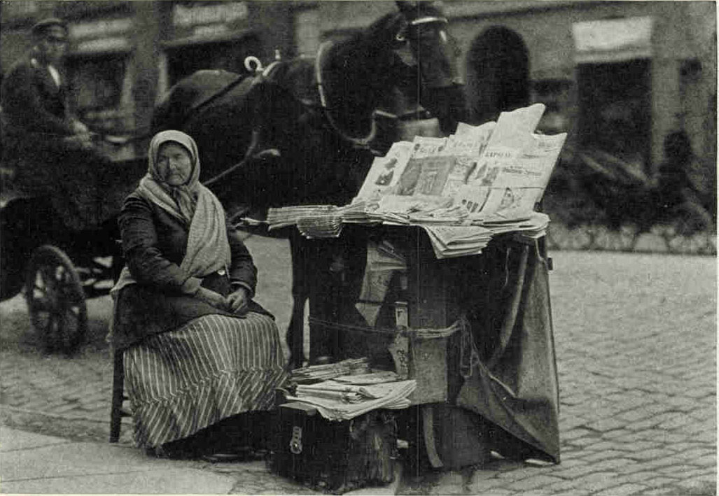 A Newsgirl of RigaLettish journals predominate, but one can also buy Russian, German and French papers and magazines, as well as the continental editions of two American and several English news-papers at this stand in the Latvian capital.Photograph by Maynard Owen Williams